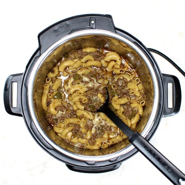 Cooked Philly Cheesesteak Pasta in Instant Pot with serving spoon