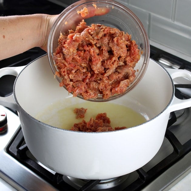 Adding sausage to large soup bowl
