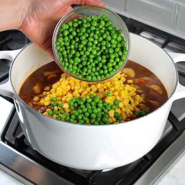 Adding peas and corn to a pot of Beef Soup