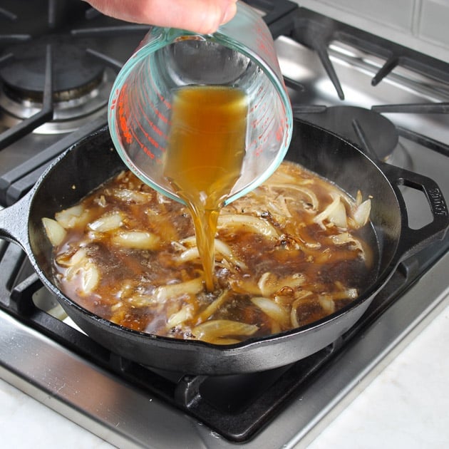 adding beef broth to cooking mushrooms