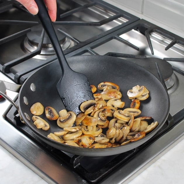 mushrooms cooking in a pan on a stove