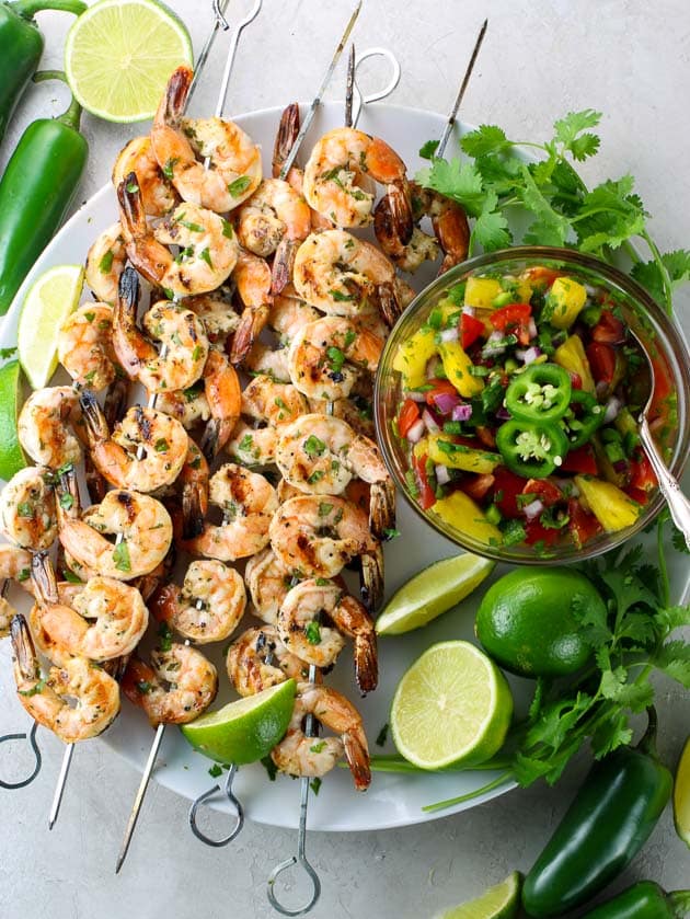 Shrimp skewers on platter with mango salsa