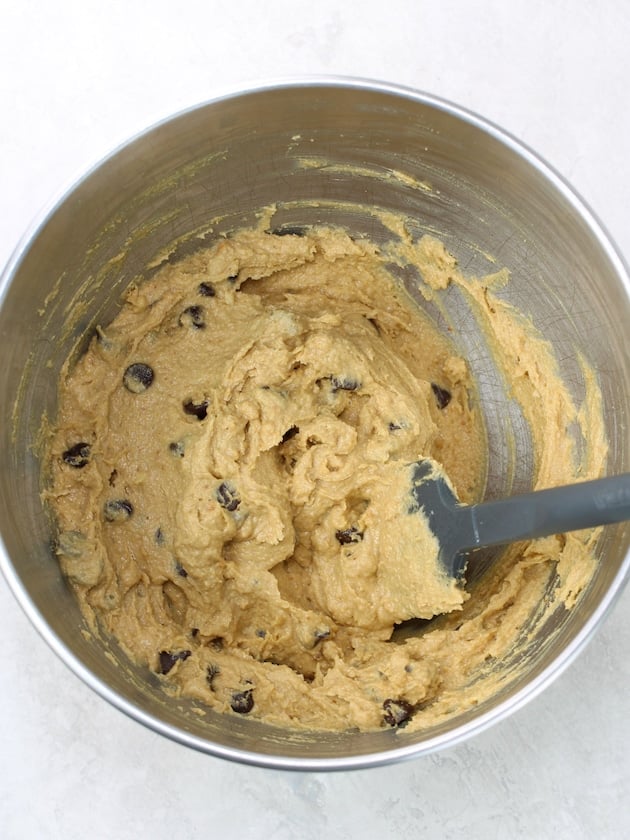 Spatula in metal mixing bowl with chocolate chip peanut butter cookie dough