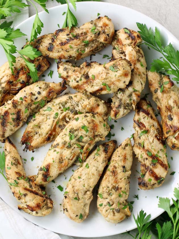 Platter of grilled chicken tenders with Italian parsley