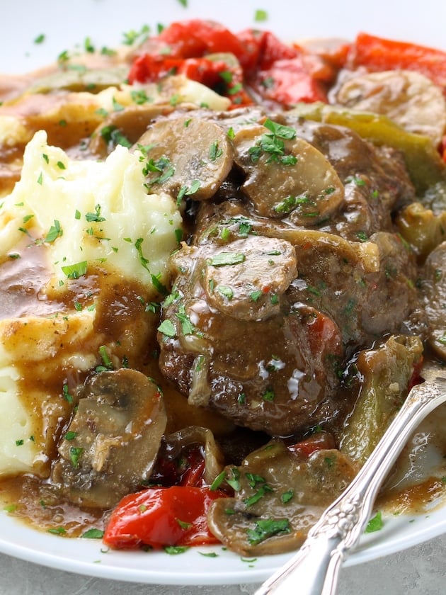Very close up partial plate of swiss steak with mashed potatoes