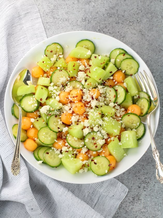 Salad on a plate with honeydew, cantaloupe, cucumber and feta