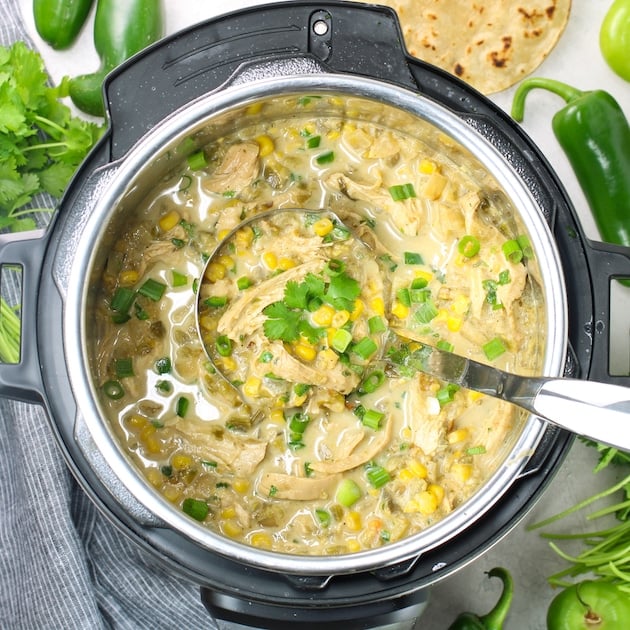 Instant Pot full of Chicken Salsa Verde Soup, with silver ladle
