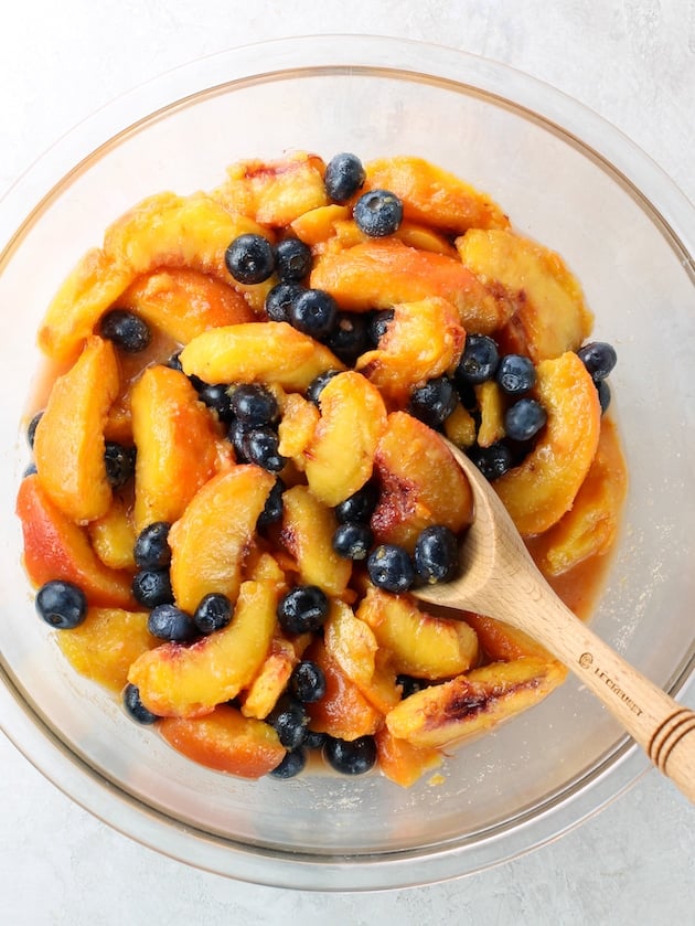 Glass bowl with blueberries and peach slices mixed together