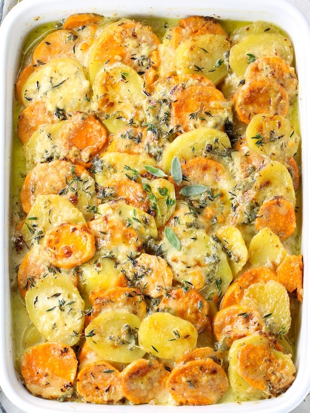 Casserole dish with sliced sweet potatoes and gold potatoes