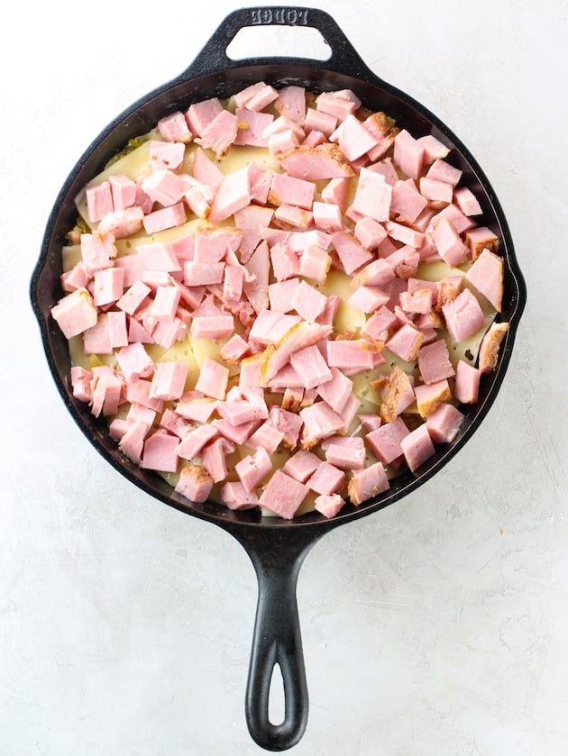 adding chunks of ham into skillet casserole