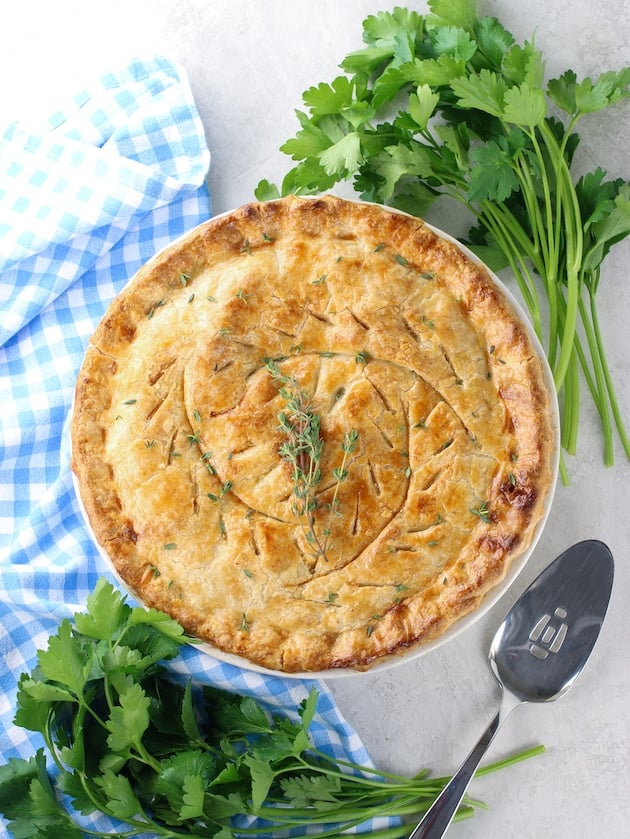 Chicken pot pie on table with parsley and napkin