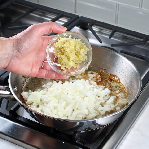 Adding minced garlic to onions in saute pan