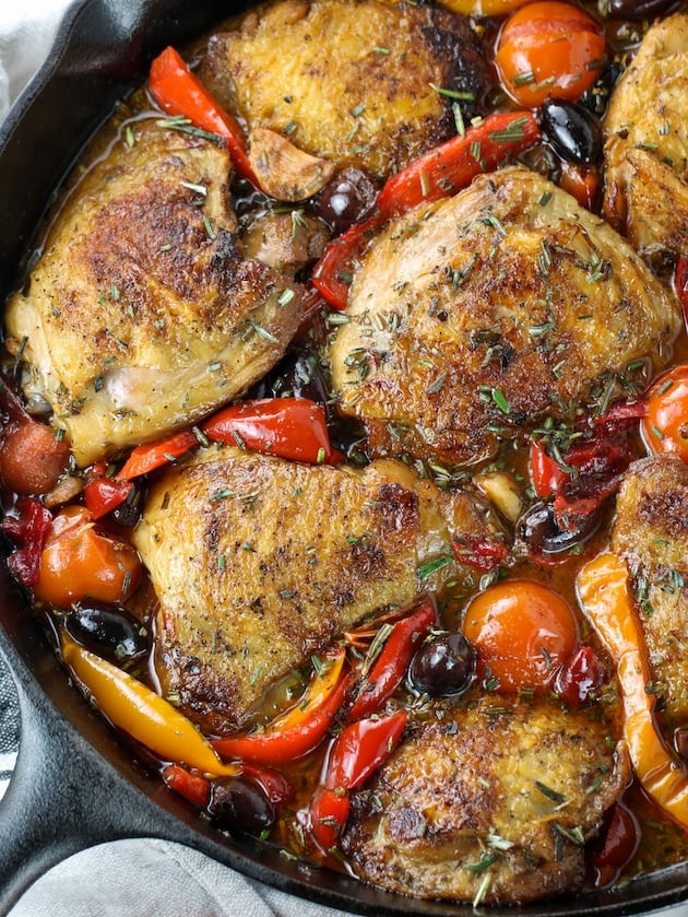 Italian chicken with herbs, cherry peppers, and kalamata olives in a skillet