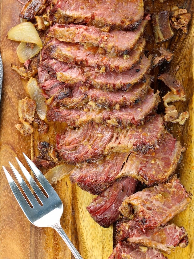 sliced st patricks' day beef brisket on cutting board with fork