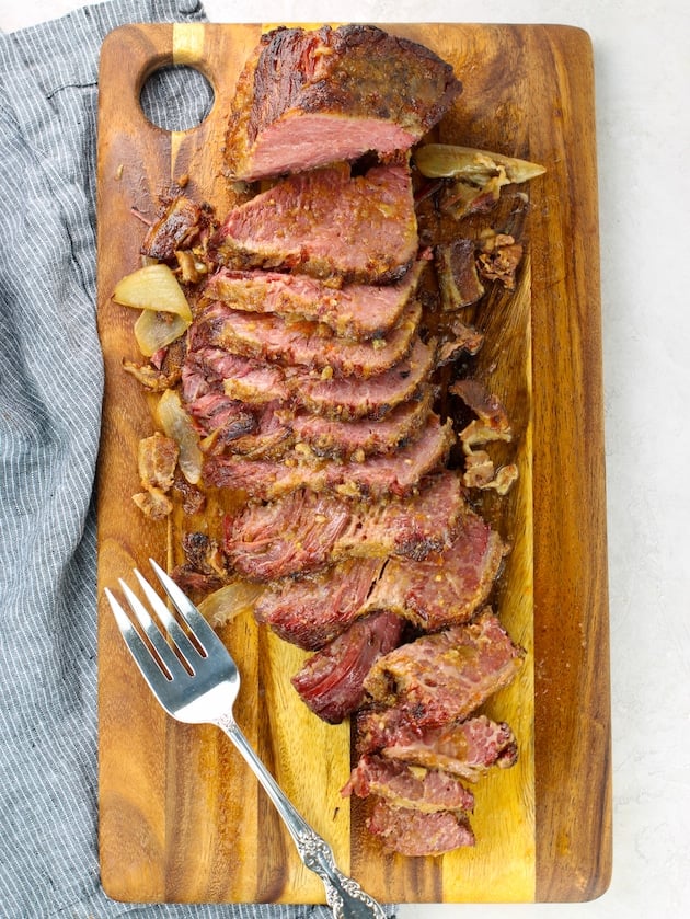 Sliced corned beef brisket on cutting board
