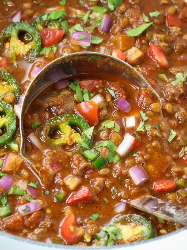 Very close up ladle in a bowl of chili