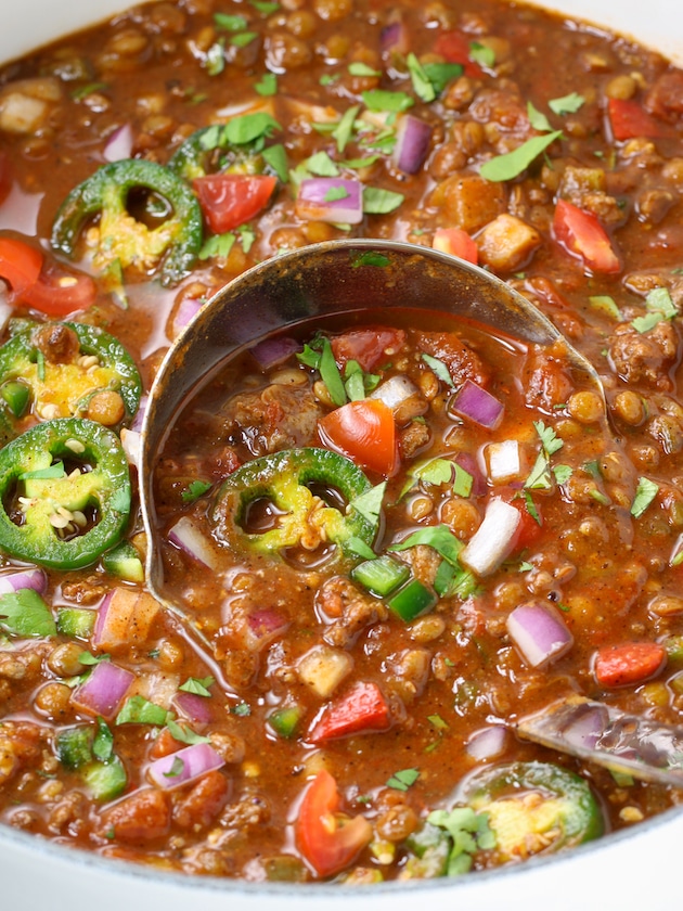 Close up eye level soup pot of Turkey Chili with silver ladle