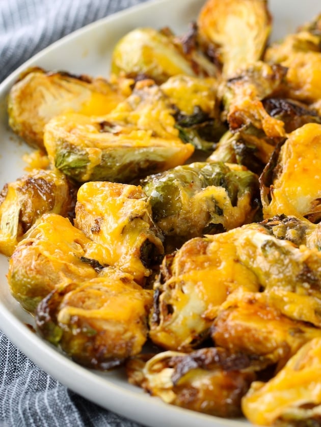 Partial plate of brussels sprouts covered in melted cheese