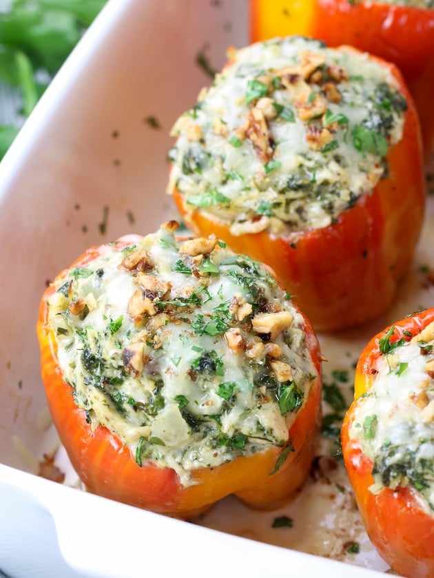 Red Yellow striped bell peppers stuffed with artichoke spinach filling