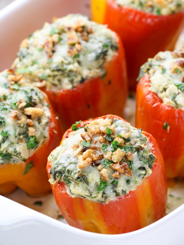 Close up eye level partial baking dish with stuffed chicken Florentine peppers 