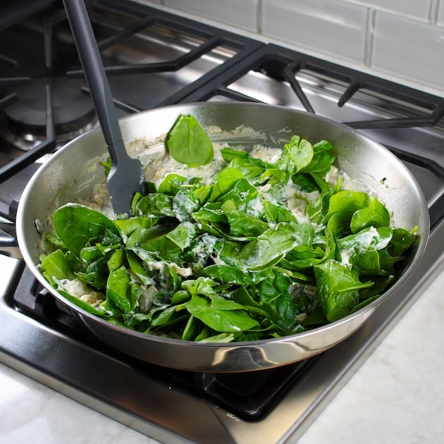 Adding fresh baby spinach to saute pan