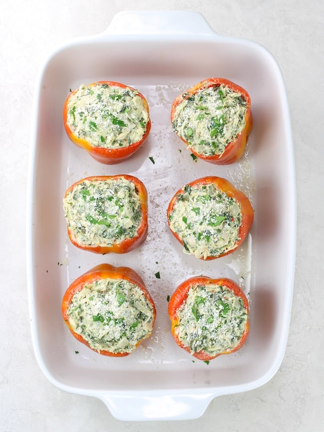 Bell peppers stuffed with chicken Florentine in a baking dish before cooking