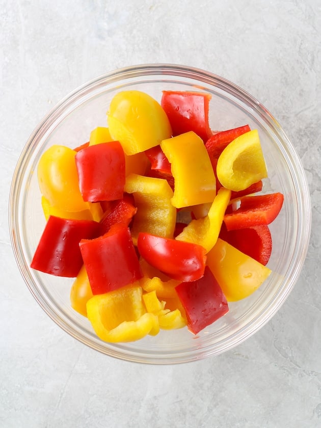 Glass bowl of chopped red and yellow bell peppers