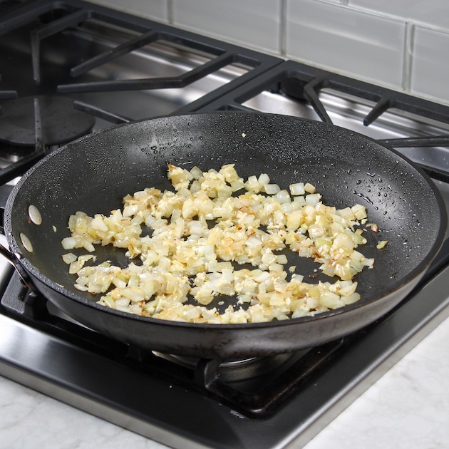 diced onions sauteeing in pan on stovetop