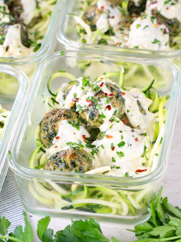 close up eye level meatballs with chicken, feta and spinach in meal prep containers