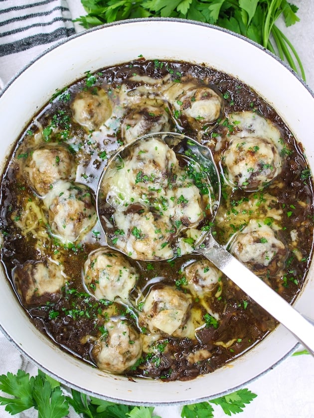Low Carb French Onion Soup with Meatballs in a large pot with a ladle.