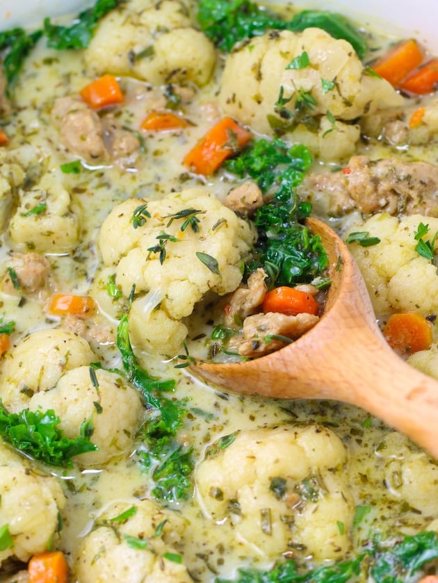 A really close-up photo of Zuppa Toscana Soup in a pot with a spoon.