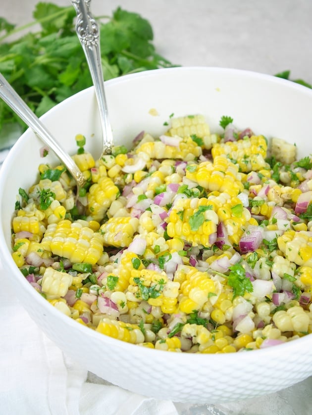 Jalapeño Cilantro Corn Salad in a serving dish with spoons