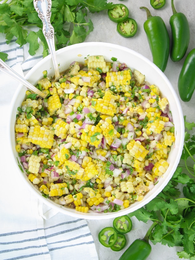 Jalapeño Cilantro Corn Salad in a serving dish with spoon dish with spoons over head