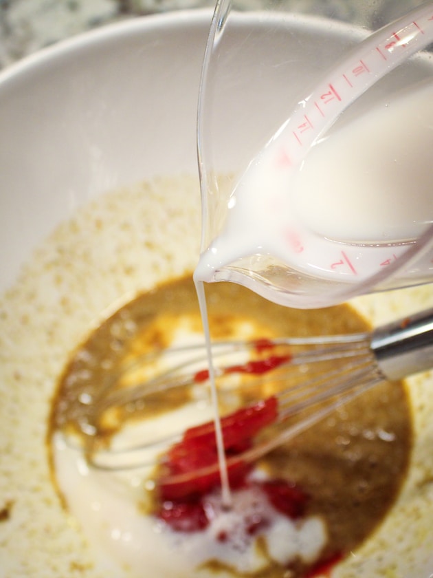Adding milk to the mixing bowl