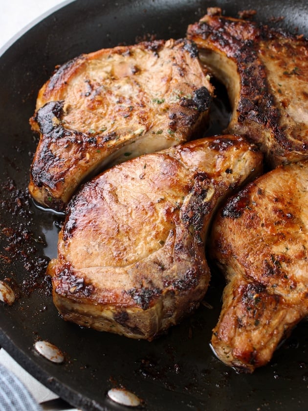 Bone-in chops pan-fried in a skillet.