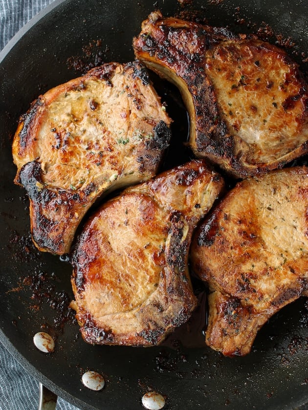 Pan-seared ranch seasoned pork chops in a skillet.