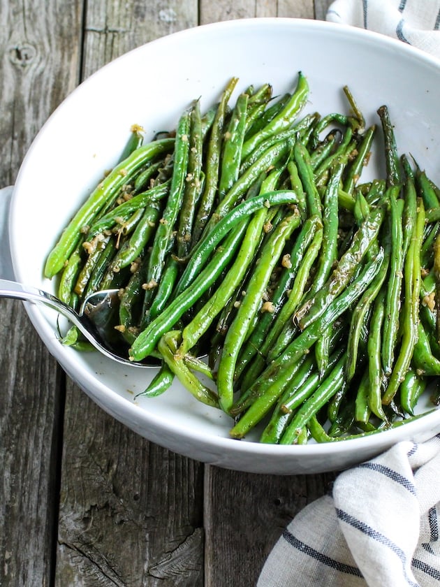 Garlic Green Beans in serving bowl, with a serving spoon.