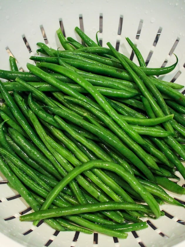 Green beans rinsed and draining in a colander.