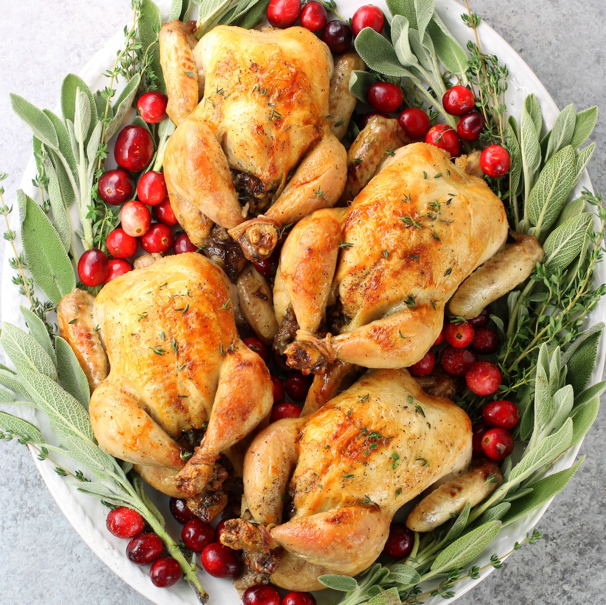 A platter with four Cornish Game Hens with Wild Rice, Mushroom, and Sausage Stuffing.