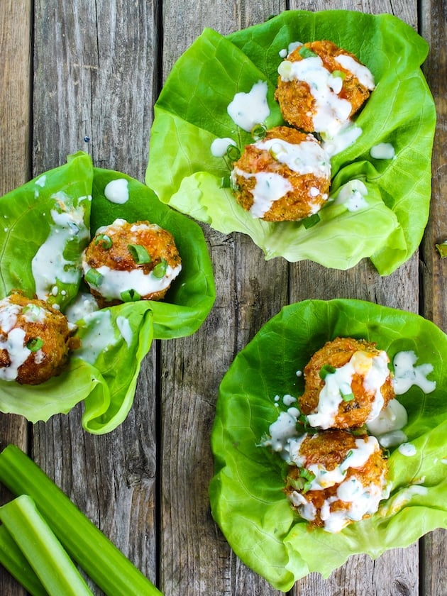 Three lettuce wraps with meatballs tossed with a spicy sauce and drizzled with blue cheese sauce.