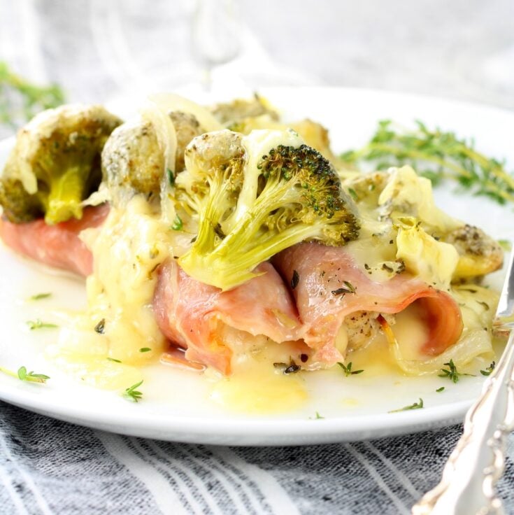 A plate with chicken cordon blue casserole with broccoli.