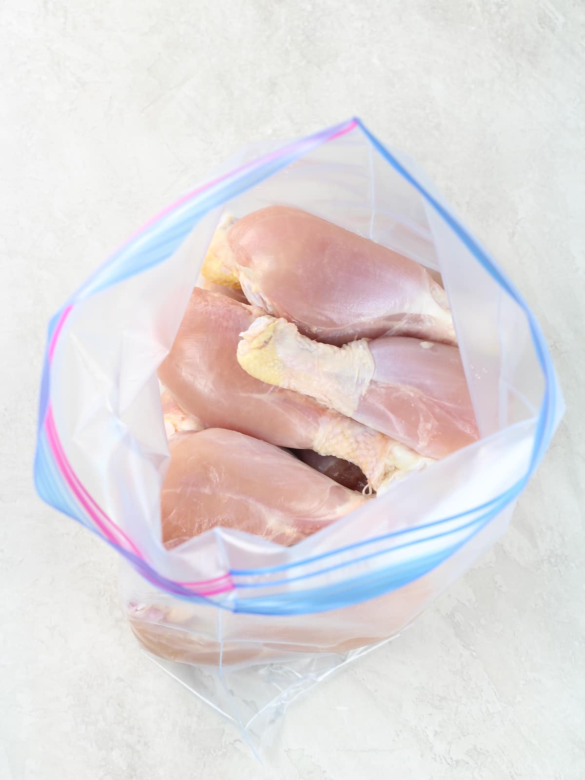 Raw drumsticks in a bag ready to be marinaded.