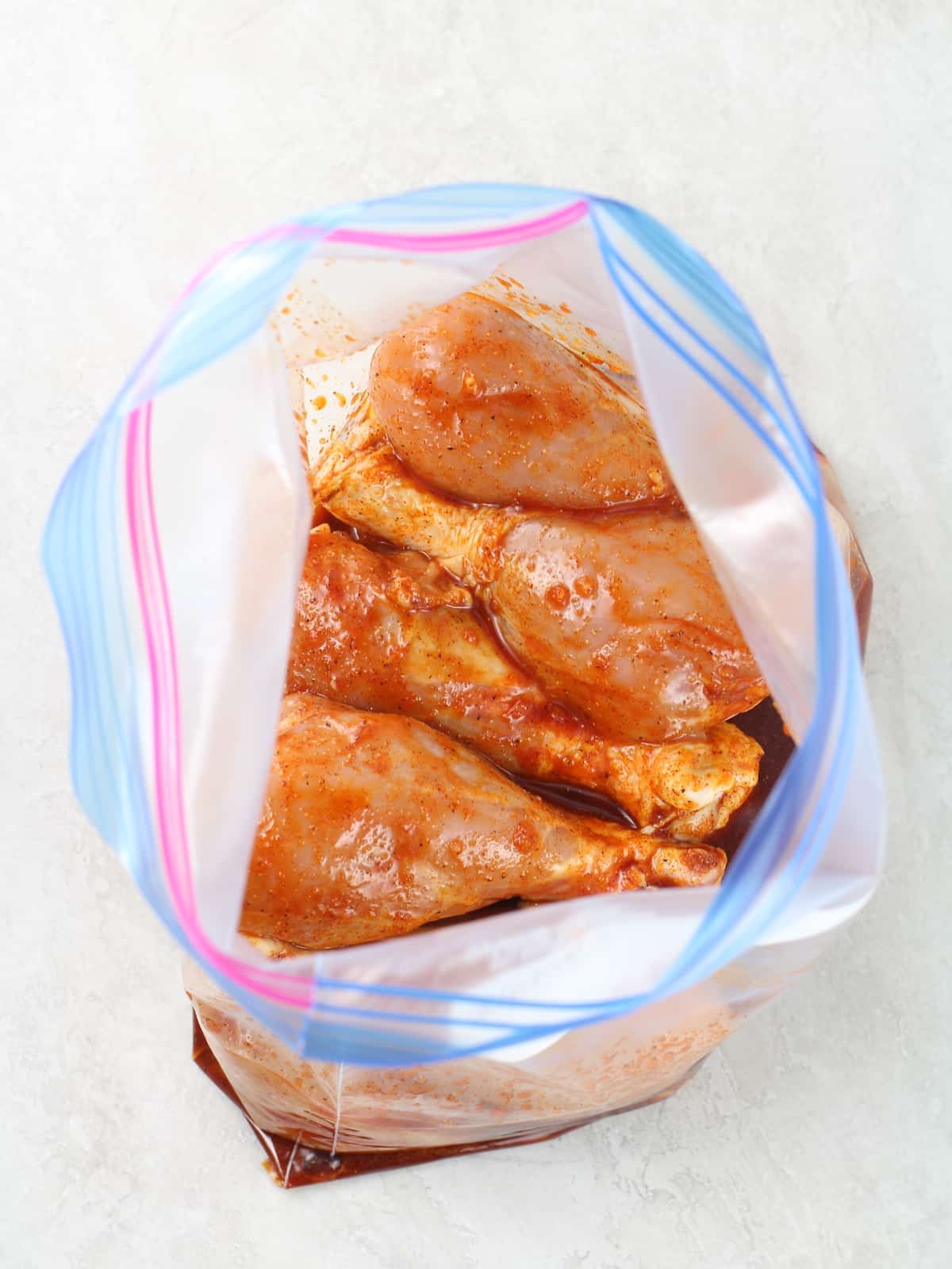 Raw drumsticks in a bag ready with marinade.