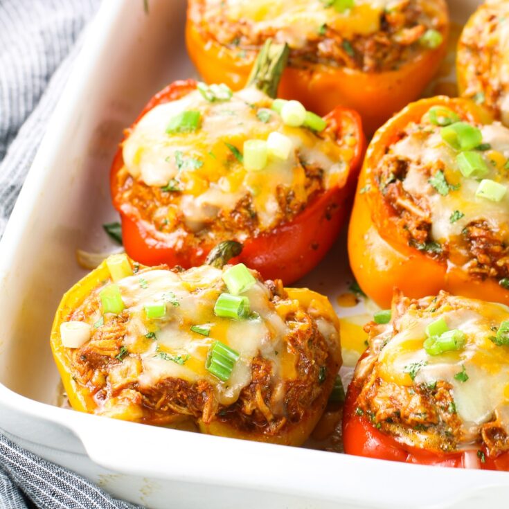 Mexican stuffed peppers cooked with cheese and sliced green onions on top.
