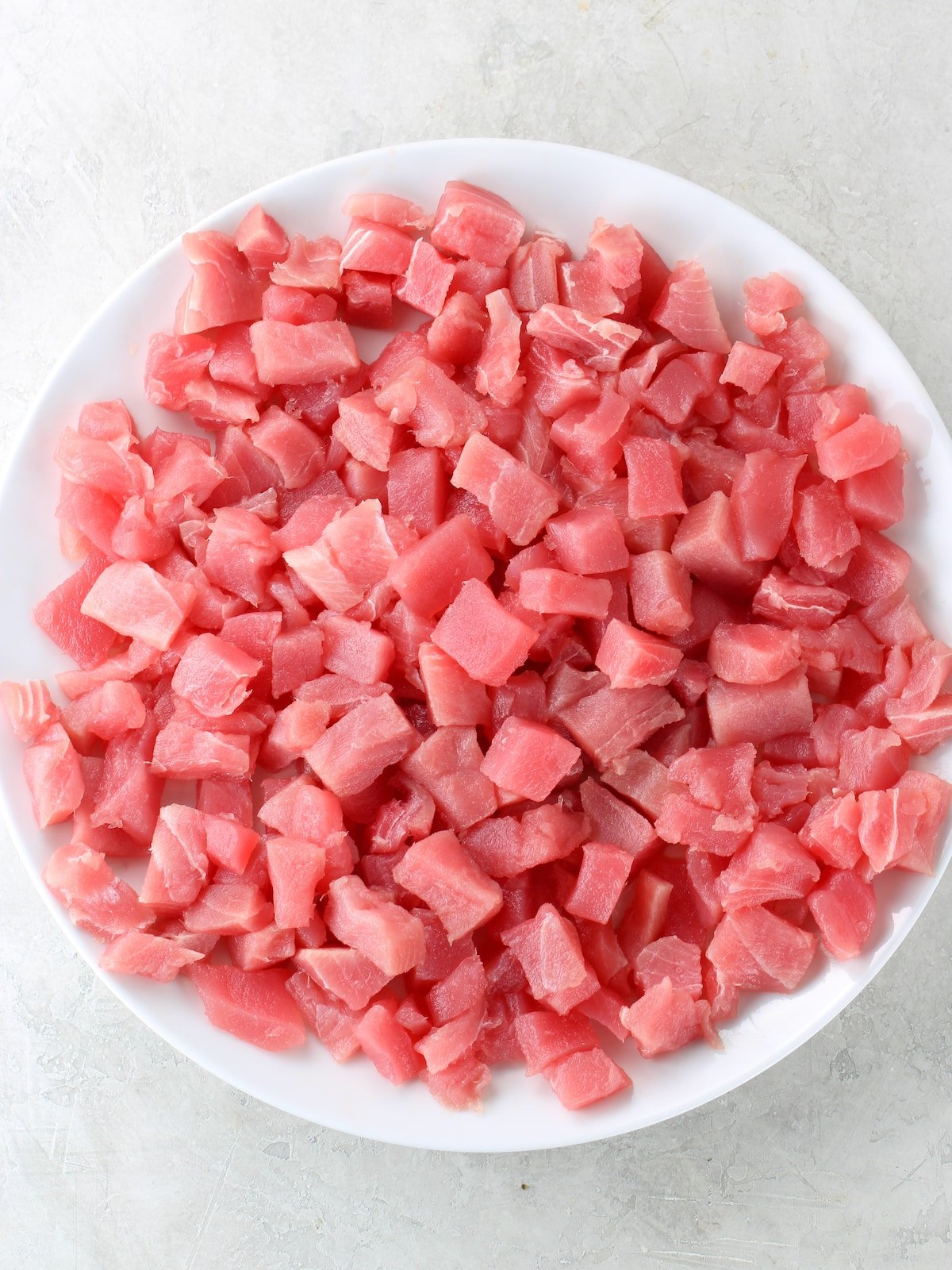Small cubes of tuna on a plate.
