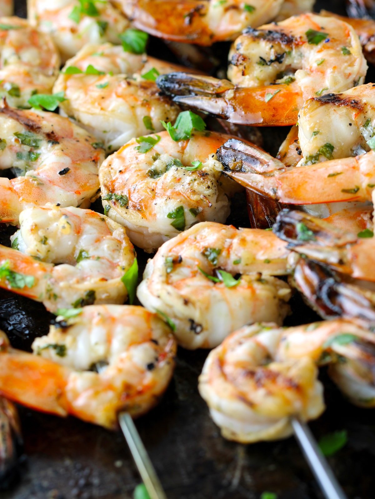 A close-up of grilled shrimp on a baking sheet.
