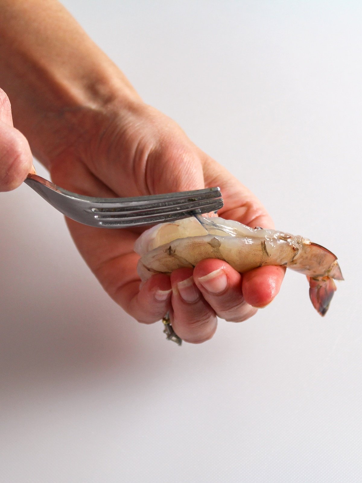 Cleaning and removing the vein from shrimp.