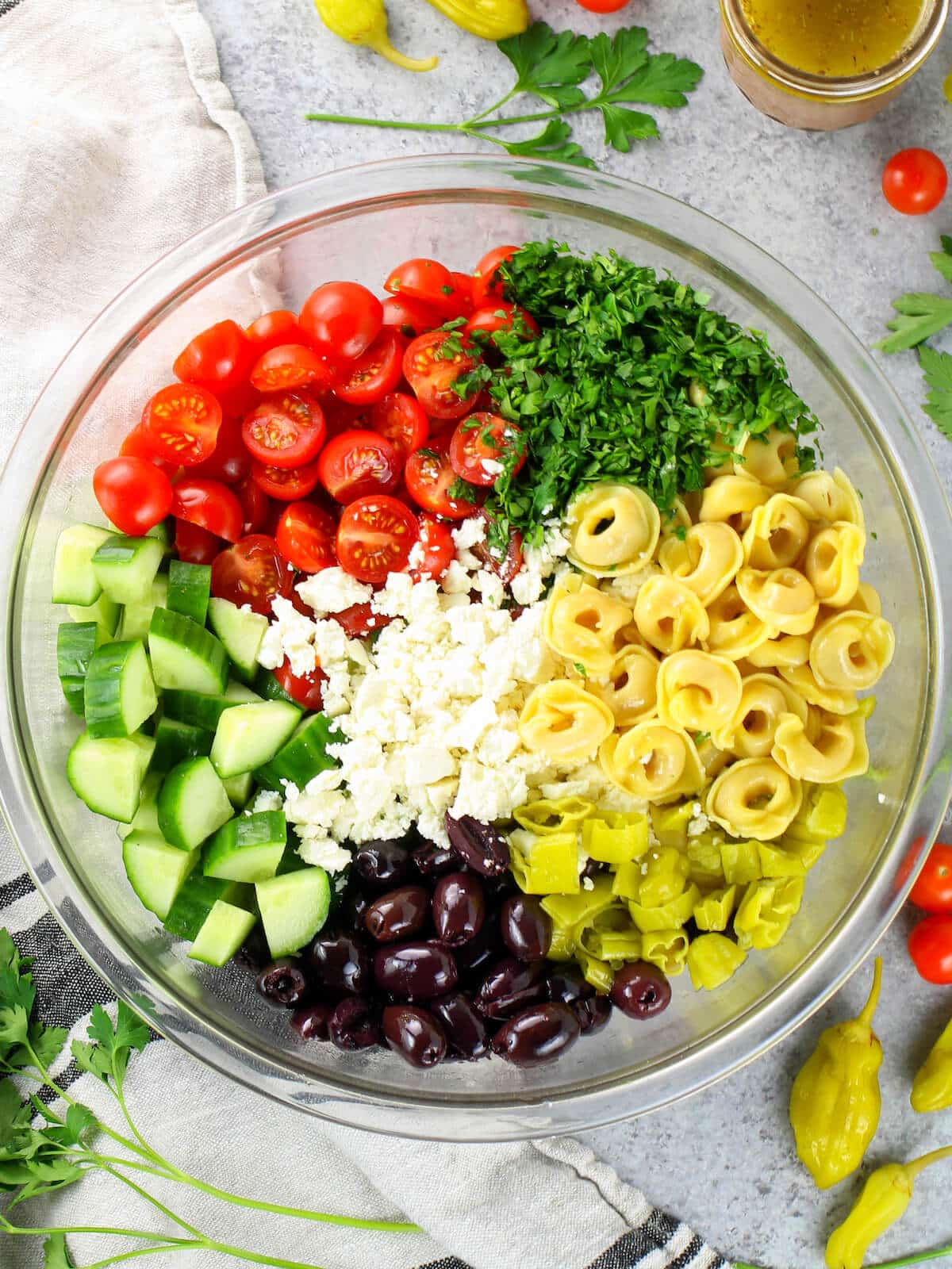 A bowl with all the ingredients for this summer Mediterranean salad.