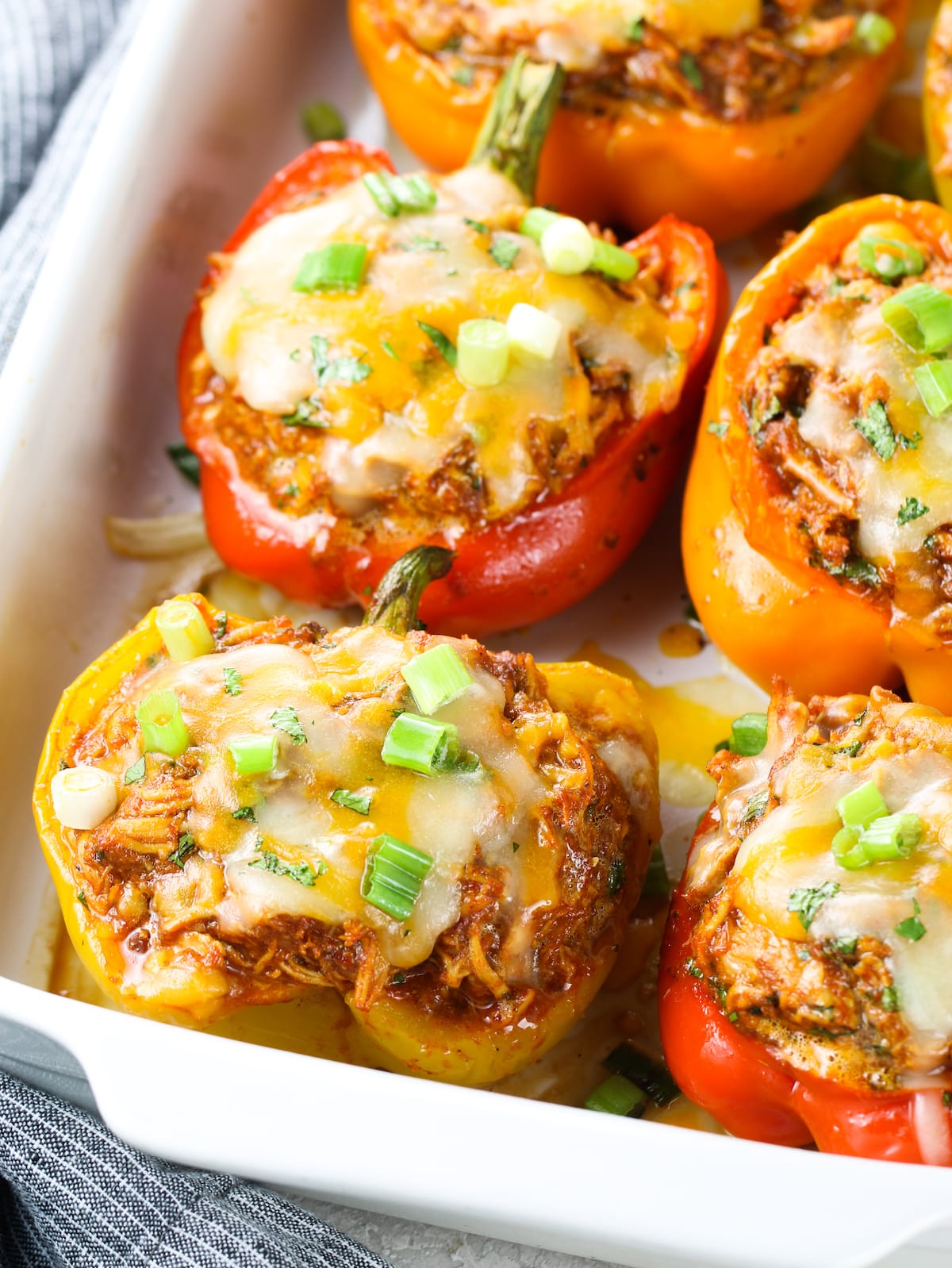 Mexican shredded stuffed peppers cooked with cheese and sliced green onions on top.