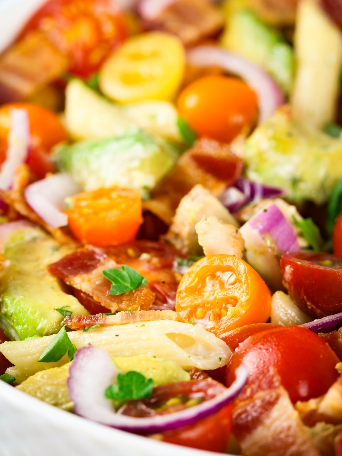 An eye-level close-up bowl of BBQ Chicken Bacon Ranch pasta salad.